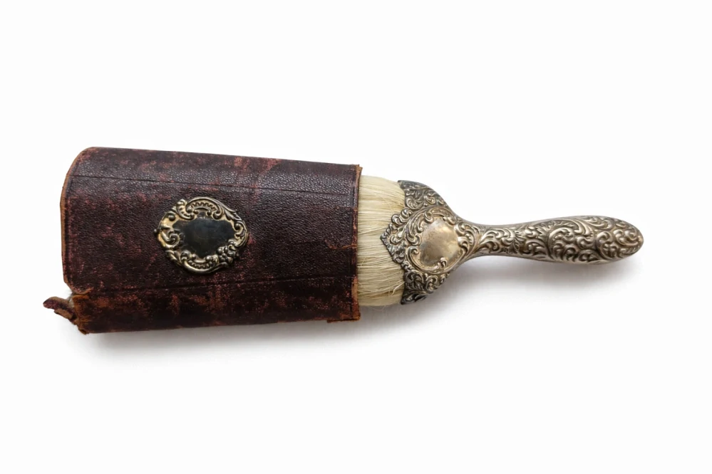 Cestovní holičský kartáč na smetání vlasů (neck brush) se stříbrnou rukojetí a koženým pouzdrem, 2. polovina 19. století (cca 1860–1900)