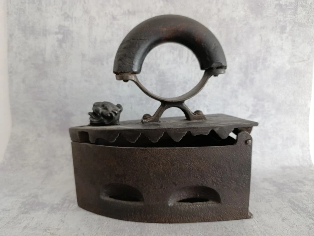 Starožitná litinová uhlíková žehlička s dřevěnou rukojetí a ozdobnou hlavou – 3,07 kg, délka 20 cm