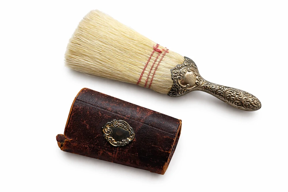 Cestovní holičský kartáč na smetání vlasů (neck brush) se stříbrnou rukojetí a koženým pouzdrem, 2. polovina 19. století (cca 1860–1900)