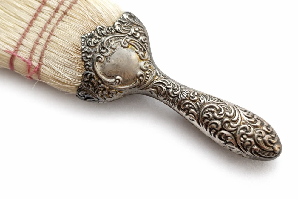 Cestovní holičský kartáč na smetání vlasů (neck brush) se stříbrnou rukojetí a koženým pouzdrem, 2. polovina 19. století (cca 1860–1900)